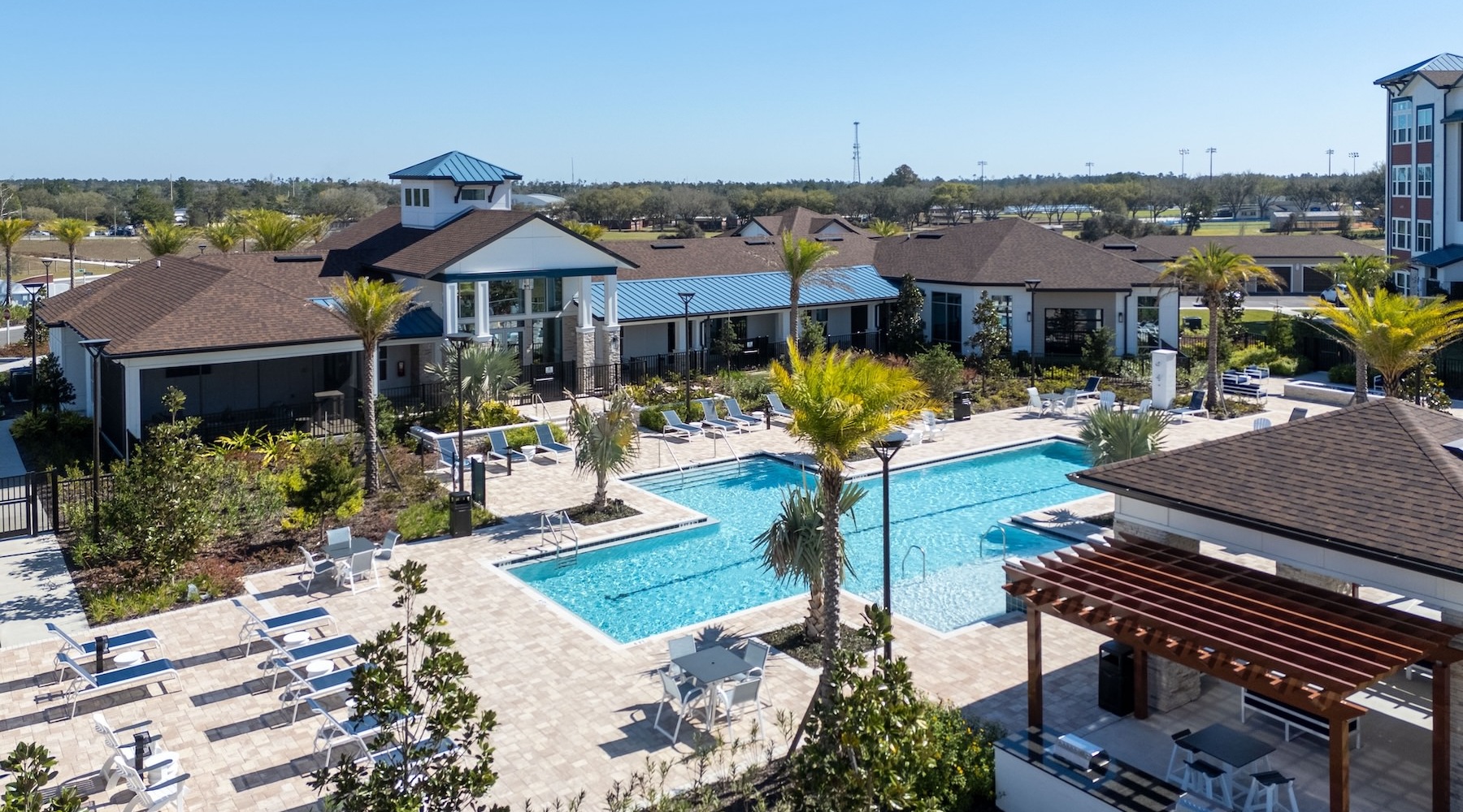 resort style pool with seating and palm trees in a courtyard