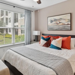 a bedroom with a fan and a bed